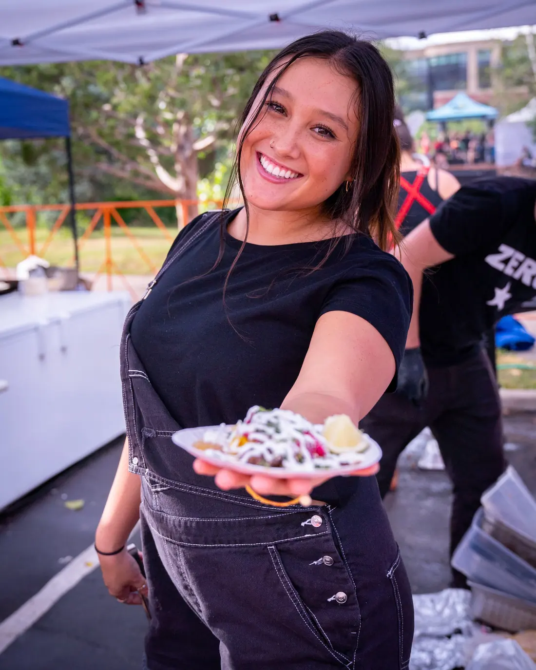 Vendor handing over a fresh taco plate